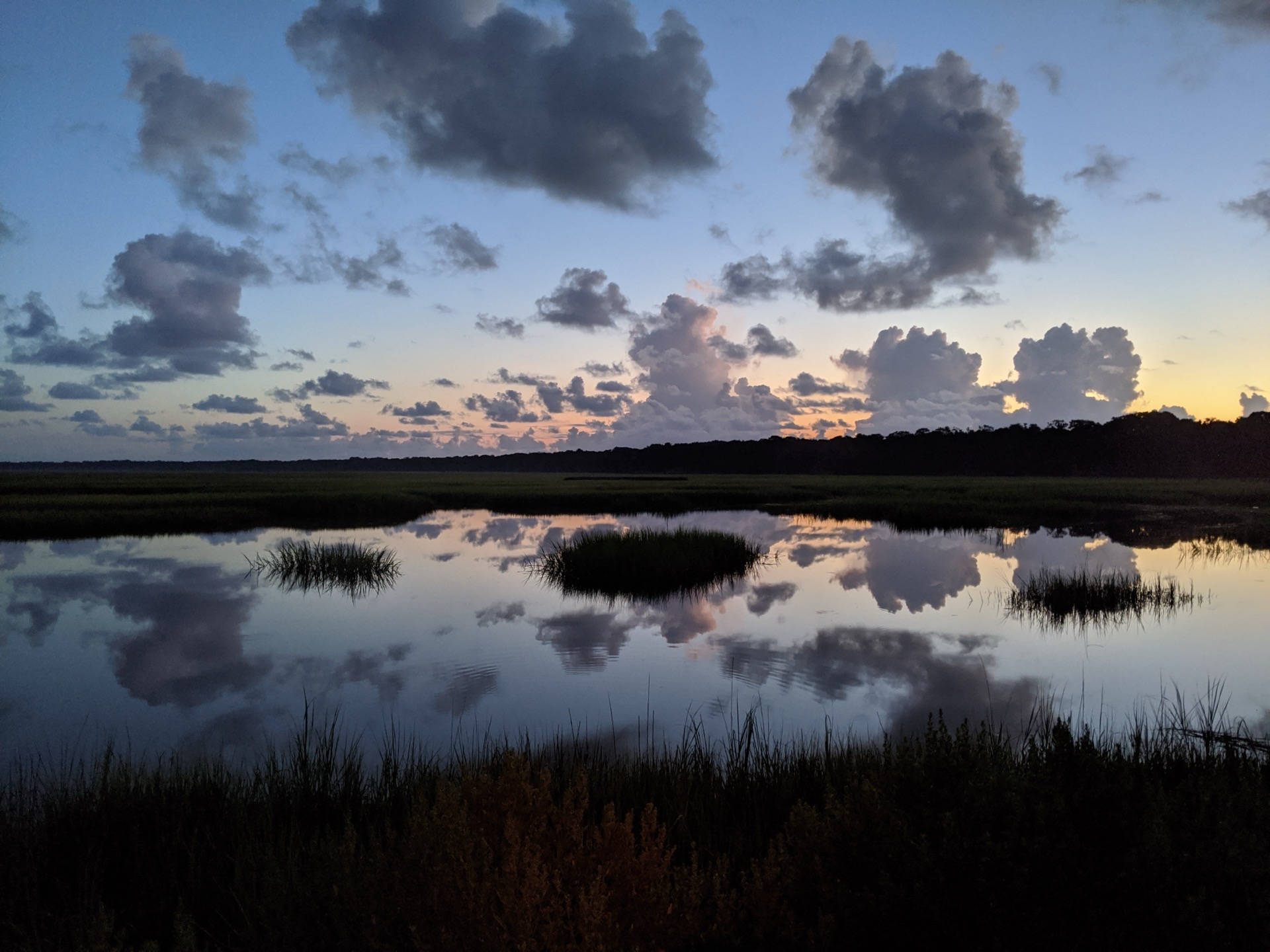Clouds reflected in still marsh water at sunset on Amelia Island